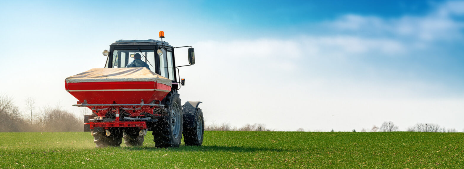 Epandage d'engrais azoté minéral en microgranulé dans un champ agricole.