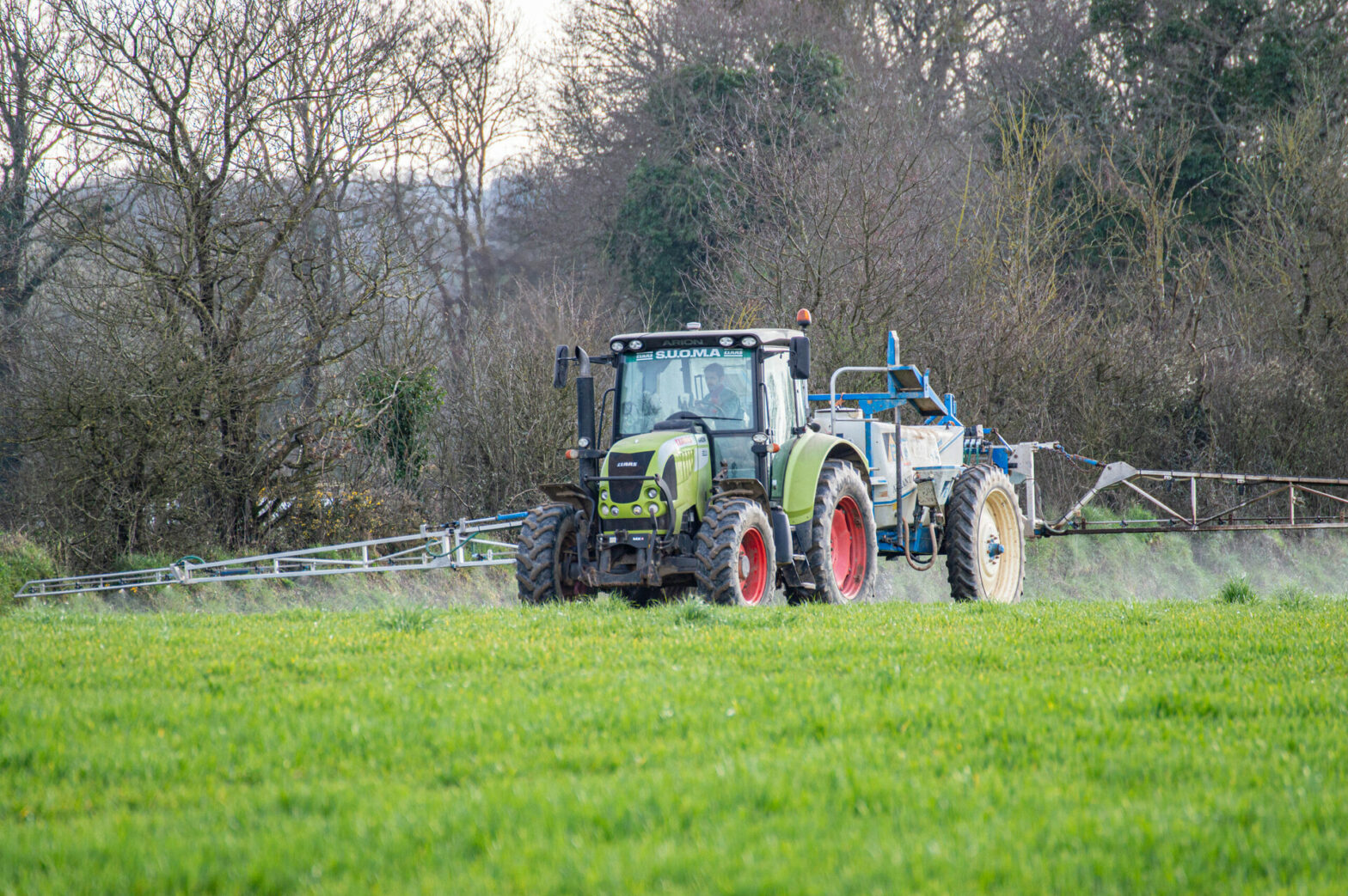 Epandage de produits phytosanitaires avec un pulvérisateur agricole.